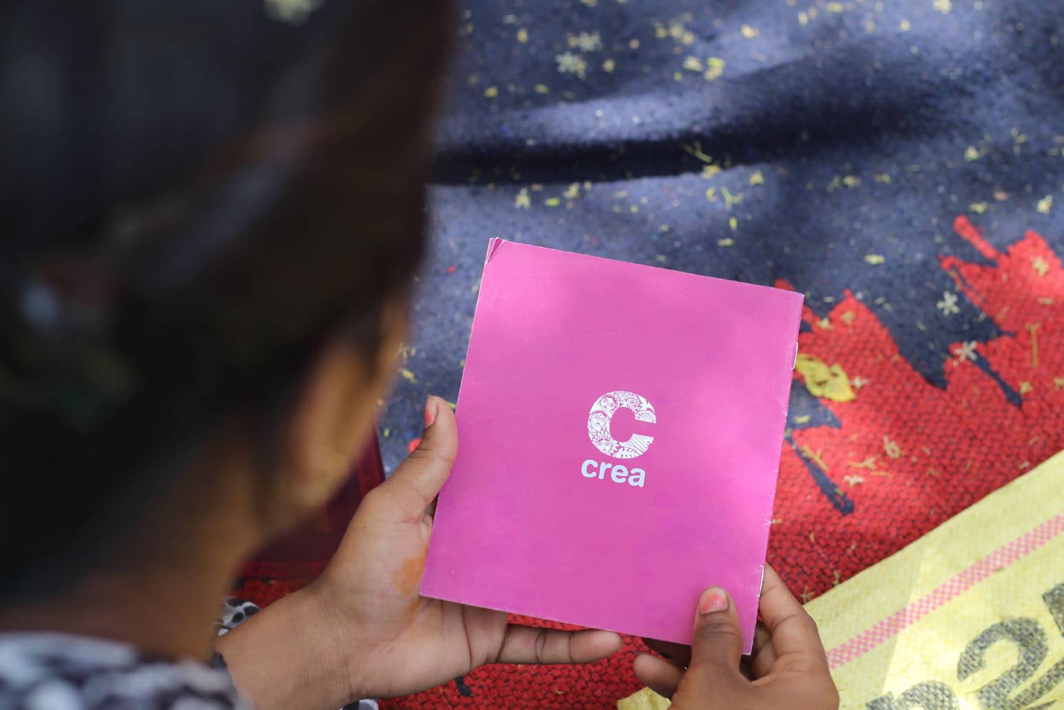 A participant looks at one of CREA's knowledge resources at a Meri Panchayat, Meri Shakti meeting